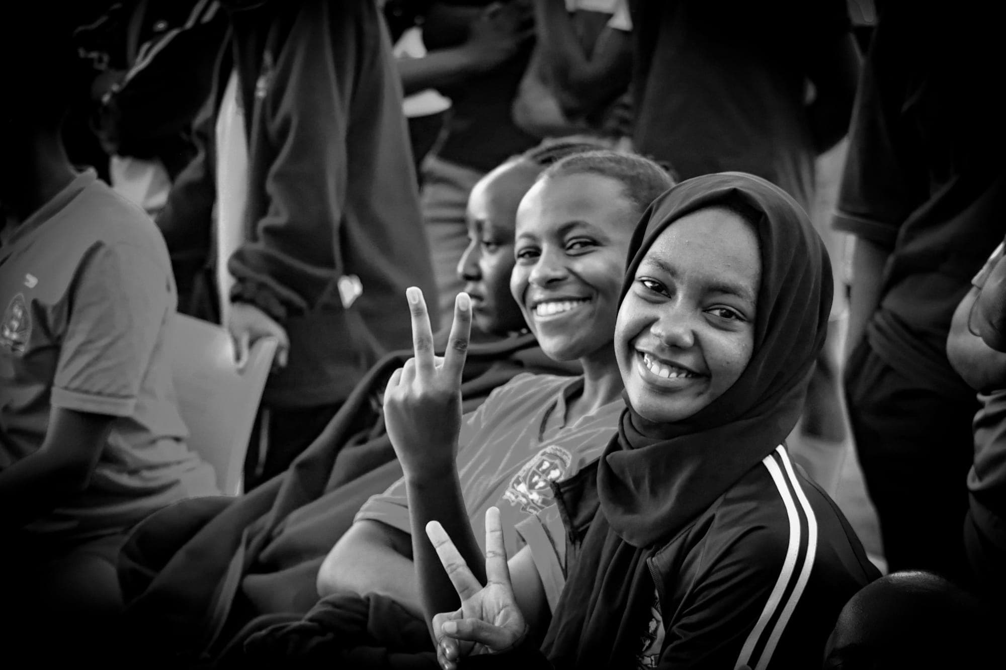 Two smiling young women flashing peace signs